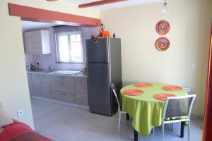 a small kitchen with a table and a refrigerator at Gîte chez Claude & Jacqueline in Neuwiller-lès-Saverne