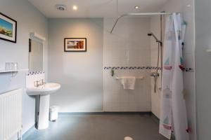 a bathroom with a shower and a sink at The Plough in Wangford