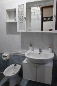 ein Badezimmer mit einem weißen Waschbecken und einem WC in der Unterkunft A.R.Inter.3 in Brescia