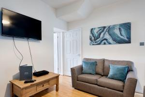 a living room with a couch and a flat screen tv at Ideal location in Morriston! in Swansea