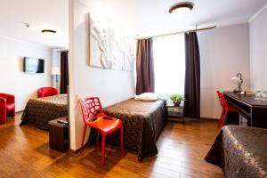 a hotel room with two beds and a desk at Primo Hotel in Riga