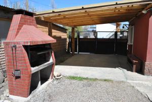 an outdoor brick oven with awning in a garage at Hostel El Reencuentro in Junín de los Andes