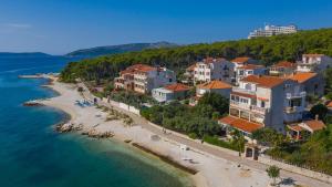 a group of houses on a beach next to the water at Apartments Marko in Trogir