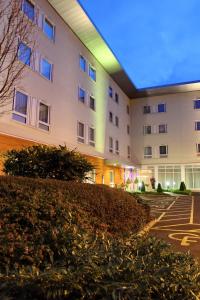 un grande edificio bianco con una luce blu di Holiday Inn Express Birmingham Redditch, an IHG Hotel a Redditch