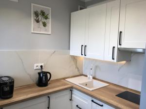 Una cocina con gabinetes blancos y un fregadero. en CENTRUM Sikorskiego 123 - EZHome, en Gorzów Wielkopolski