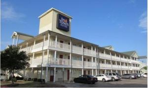 un gran hotel con coches estacionados en un estacionamiento en Intown Suites Extended Stay Dallas TX - Garland, en Garland