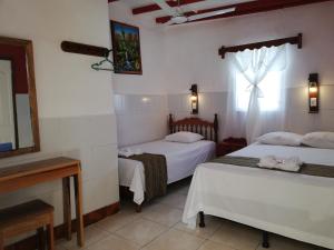 two beds in a room with a window at Hotel La Union in Flores +48 photos