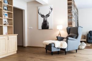 una sala de estar con una silla azul y una pintura de ciervos en Ski in - Ski out Schladming NEM Alpin Chalet, en Schladming