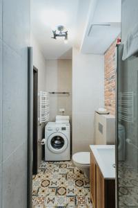 a bathroom with a toilet and a washing machine at Singer Retro Studio in Kazimierz in Kraków +14 photos