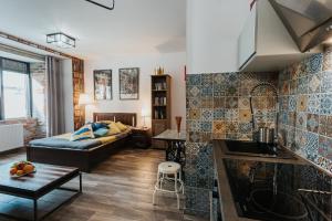 a kitchen and living room with a couch and a table at Singer Retro Studio in Kazimierz in Kraków