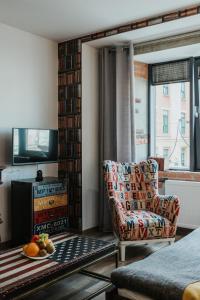 a living room with a chair and a television at Singer Retro Studio in Kazimierz in Kraków