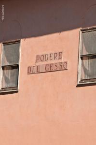 タルクイーニアにあるPodere Del Gessoのピンクの建物の側面二面窓