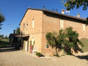 un edificio de ladrillo con un árbol delante de él en Agriturismo "La Fondazza", en Imola