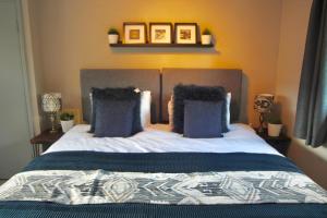 a bedroom with a large bed with blue pillows at Hambleton House in Catterick Garrison