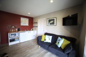 a living room with a couch and a kitchen at Pedalfish Cottages - Milky Way in Twizel