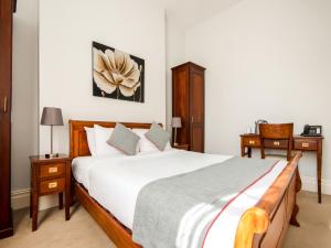 1 dormitorio con 1 cama grande y 2 mesitas de noche en OYO the Regency, Clifton Bristol en Bristol