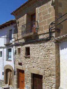 an old stone building with a balcony on top of it at Casa Loriente in Murillo de Gállego