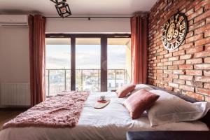 a bed in a room with a brick wall at Glamour Apartment City View in Wrocław