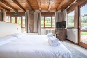 Schlafzimmer mit einem großen weißen Bett und Fenstern in der Unterkunft La Quercia - BolognaRooms in Sasso Marconi