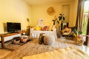 een woonkamer met een bed en een televisie bij Chalé Carpe Diem - Pipa Beleza in Pipa