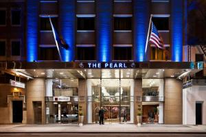 un hombre parado frente a un edificio en The Pearl Hotel, en Nueva York