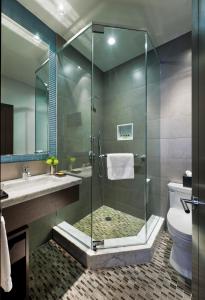 
a bathroom with a shower, toilet, sink and tub at The Pearl Hotel in New York
