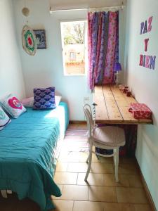 1 dormitorio con cama, escritorio y mesa en Alojamiento familiar en Coronel Suárez