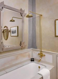 a bathroom with a bath tub with a mirror at Blakes Hotel in London