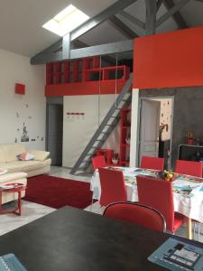 een woonkamer met rode stoelen en een trap bij maison de Bergerac in Bergerac