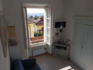 uma sala de estar com uma janela e um sofá azul em Le Palmaro em Menton