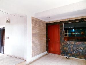 una puerta roja en un edificio con una pared de piedra en SOCRA Félix Bogado CASA ENTERA PARA 7 PERSONAS, en Asunción