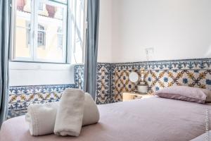 a bedroom with a bed and a window at Azulejos Cais Sodré B&B in Lisbon