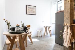 a kitchen with a table and a refrigerator at Azulejos Cais Sodré B&B in Lisbon