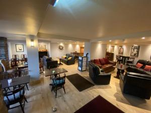 einen Blick über das Wohnzimmer mit Sofas und Tischen in der Unterkunft Kylemore Pass Hotel in Letterfrack