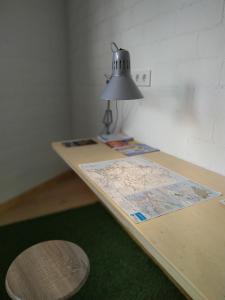 a table with a lamp and a map on it at Albergue Nacama Hostel Pontevedra EXCLUSIVO PEREGRINOS PILGRIMS in Pontevedra +11 photos