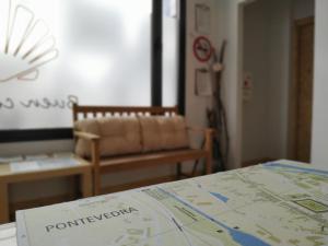 a map on a table with a couch in a room at Albergue Nacama Hostel Pontevedra PEREGRINOS PILGRIMS in Pontevedra
