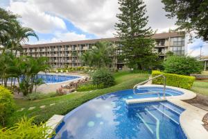 a resort with two pools and a building at Irazú Hotel & Studios in San José