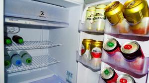an open refrigerator filled with bottles and drinks at Flat 02 in Jaguariaíva