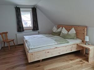 a bedroom with a wooden bed and a window at Biohof Gölly in Neumarkt in Steiermark