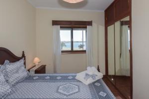 a bedroom with a bed with a view of the ocean at L'ALCIBÍADES - Costa Nova in Costa Nova