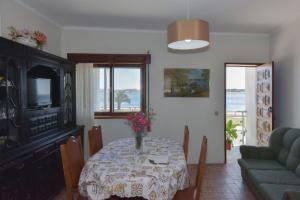 a dining room with a table with flowers on it at L'ALCIBÍADES - Costa Nova in Costa Nova