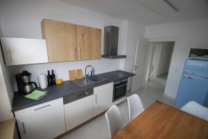 a kitchen with a sink and a table with chairs at Apartment AusZeit in Bad Kissingen