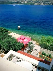 an aerial view of the ocean with a pink umbrella at Apartments Natasa in Trogir
