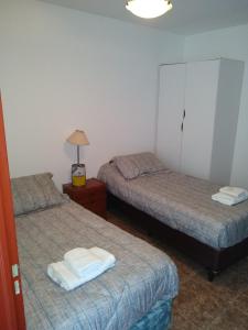 Habitación con 2 camas y una lámpara en una mesa. en Amplio departamento Barrio Jardin en Córdoba