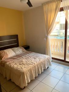 a bedroom with a bed and a large window at Hotel Posada San Juan in Veracruz
