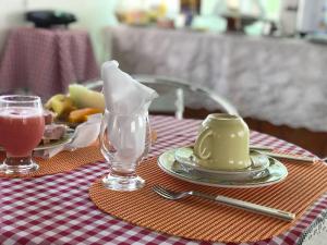 a table with a plate of food and a drink at Pousada Tiriri Guesthouse in Barra do Camaragibe
