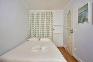 a bedroom with a bed with two slippers on it at Aesthetic Riverview Apartment in Historical Lisbon in Lisbon