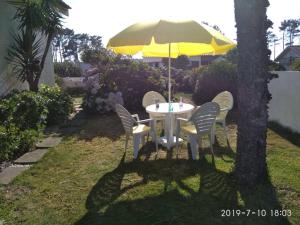 a table and chairs under an umbrella in a yard at Casa Amarela in Esmoriz +8 photos