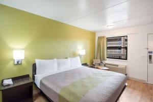 a hotel room with a large bed and a living room at Studio 6 Colorado Springs, Colorado - Air Force Academy in Colorado Springs