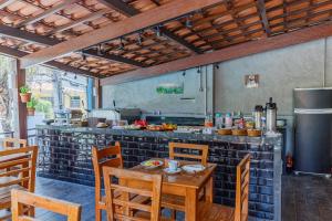 cocina con mesa, sillas y nevera en Hotel Meireles, en Fortaleza